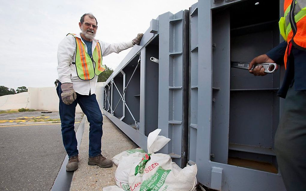 Een gemeentewerker sluit een waterkering bij New Orleans. De tropische storm Isaac is in aantocht. Foto EPA