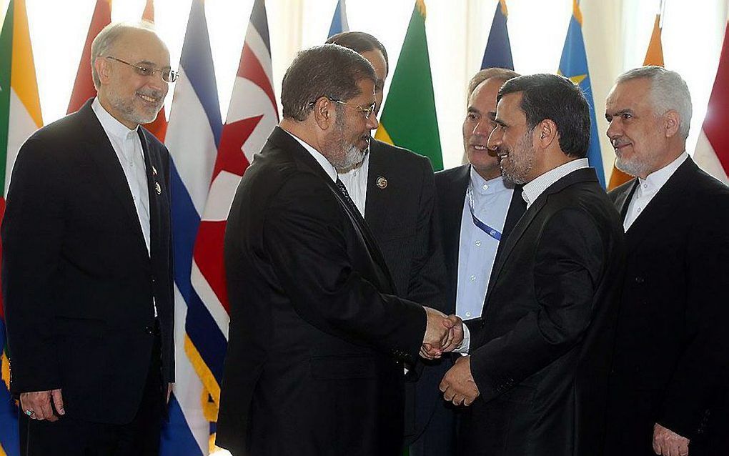 Mohammed Mursi (links) en Mahmoud Ahmadinejad schudden elkaar donderdag de hand. Foto EPA