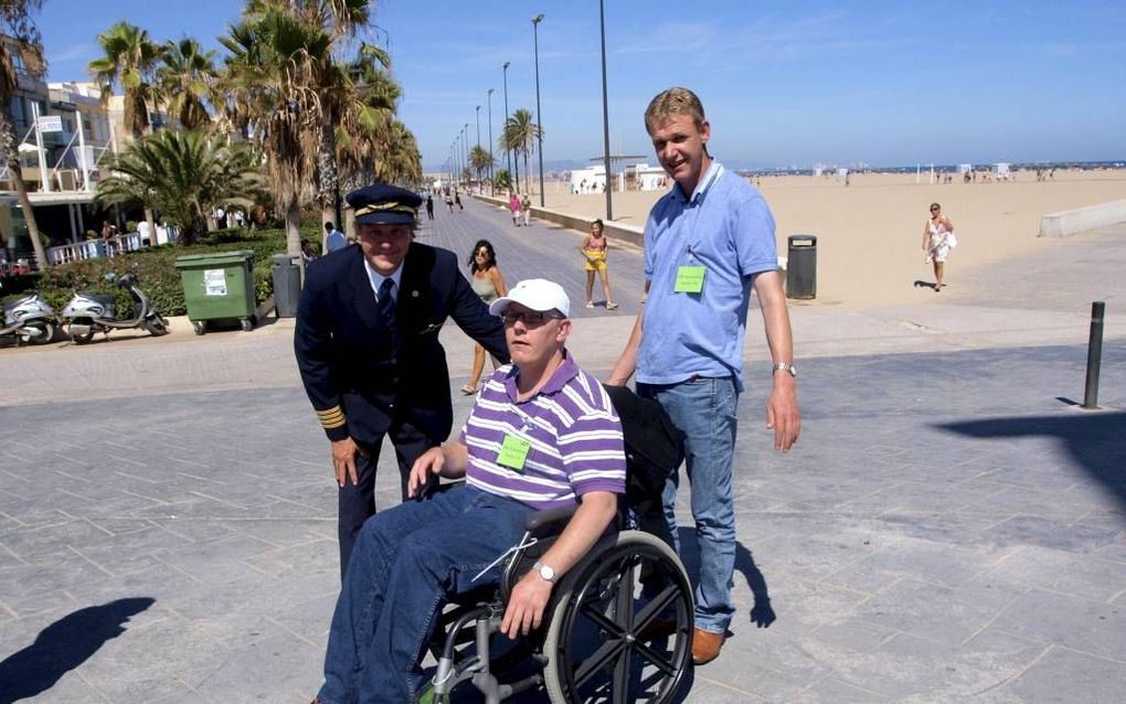 Twee Rijssense broers, zaterdag van de partij tijdens een door KLM en reisorganisatie TUI Nederland gesponsorde vliegreis voor gehandicapten naar Valencia, poseren met een van de bemanningsleden. Foto Jasper van den Bovenkamp