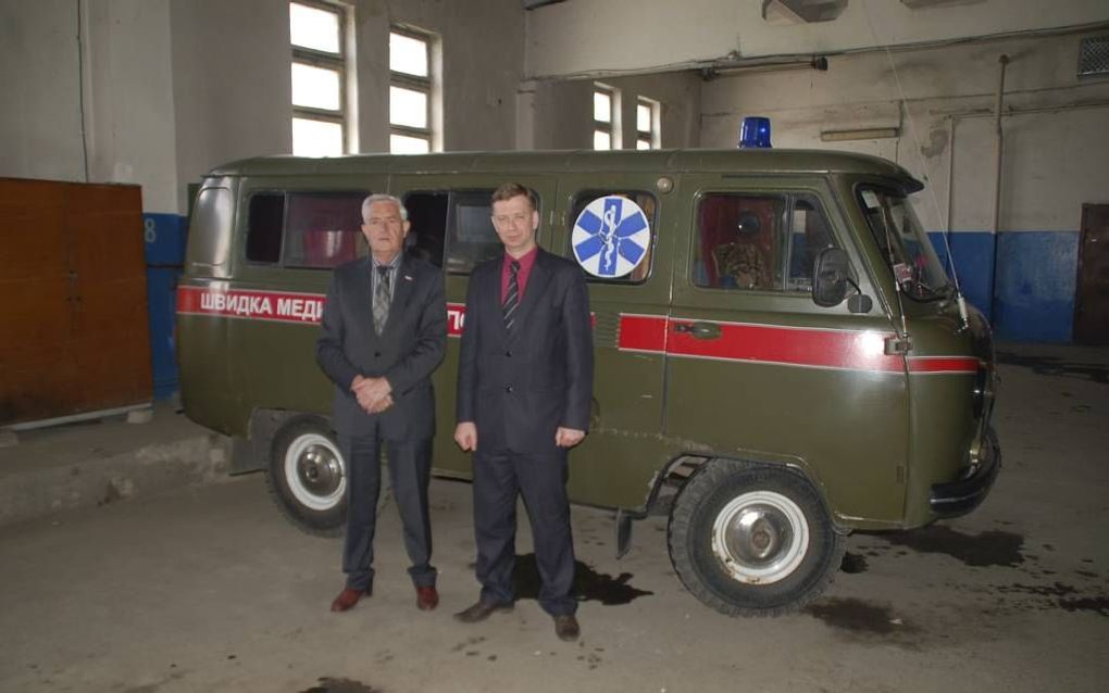 L. J. Luchtenburg (l.), voorzitter van de SOEGG, voor een van de verouderde Oekraïense ambulances in een ziekenhuis in Zhitomir. Foto SOEGG