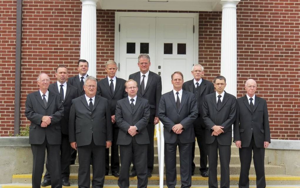 De bij de synode van de Netherlands Reformed Congregations (NRC) aanwezige predikanten voor de ingang van het kerkgebouw in Grand Rapids. V.l.n.r., vooraan: ds. C. Vogelaar, ds. A. Moerkerken, ds. E. Hakvoort, ds. P. van Ruitenburg, ds. H. D. den Hollande