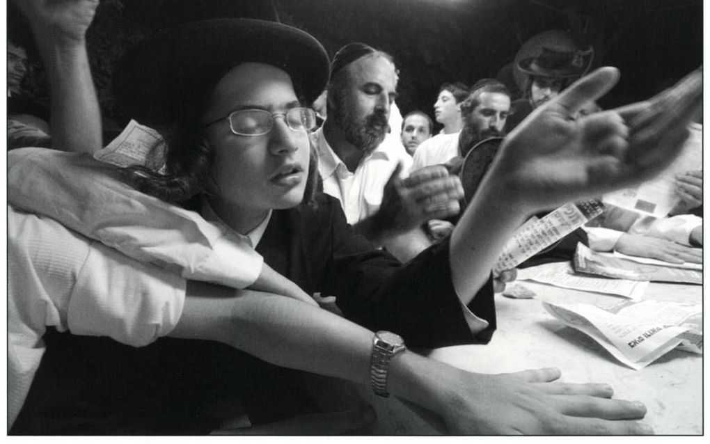 Een chassidische jongen bidt vol overgave bij het graf van de tzadiek van Shtefanesht, rabbijn Avraham Mattisyahu Friedman. Tel Aviv, 2006. De tzadiek stierf in 1933. Zijn stoffelijke overschot werd in 1969 naar Israël gebracht. Foto Yuval Nadel, Israël M