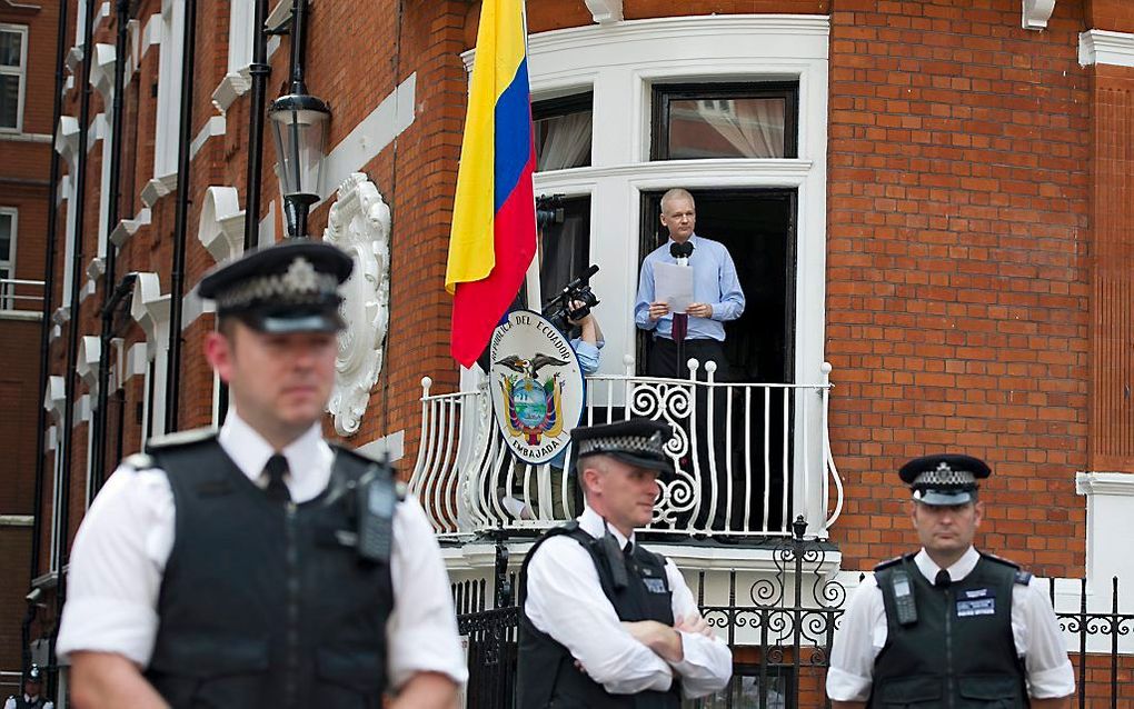 Assange houdt een toespraak vanuit de ambassade van Ecuador in Londen. Foto EPA