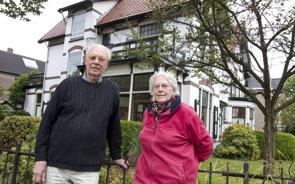 Dick de Vries en Tine Olthoff voor hun monumentale woning in de Apeldoornse wijk de Parken. „Je moet van zo’n huis houden, anders wordt het een puinhoop.” Foto RD, Anton Dommerholt