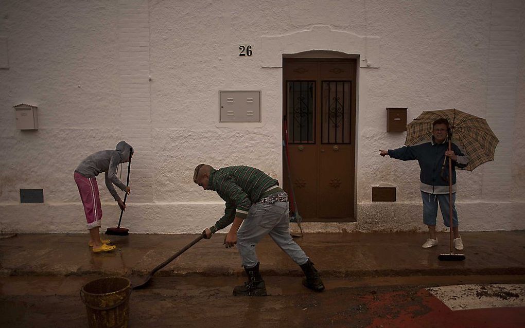 Mensen maken straat en huizen schoon in de Spaanse provincie Málaga. Foto EPA