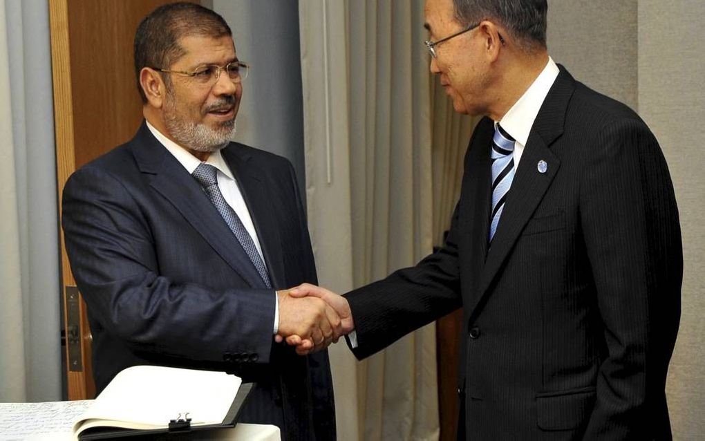 De Egyptische president Morsi (l.) schudt de hand van VN-secretaris-generaal Ban Ki Moon. Het kersverse staatshoofd timmert volop aan de weg, onder andere met buitenlandse reizen. Foto EPA