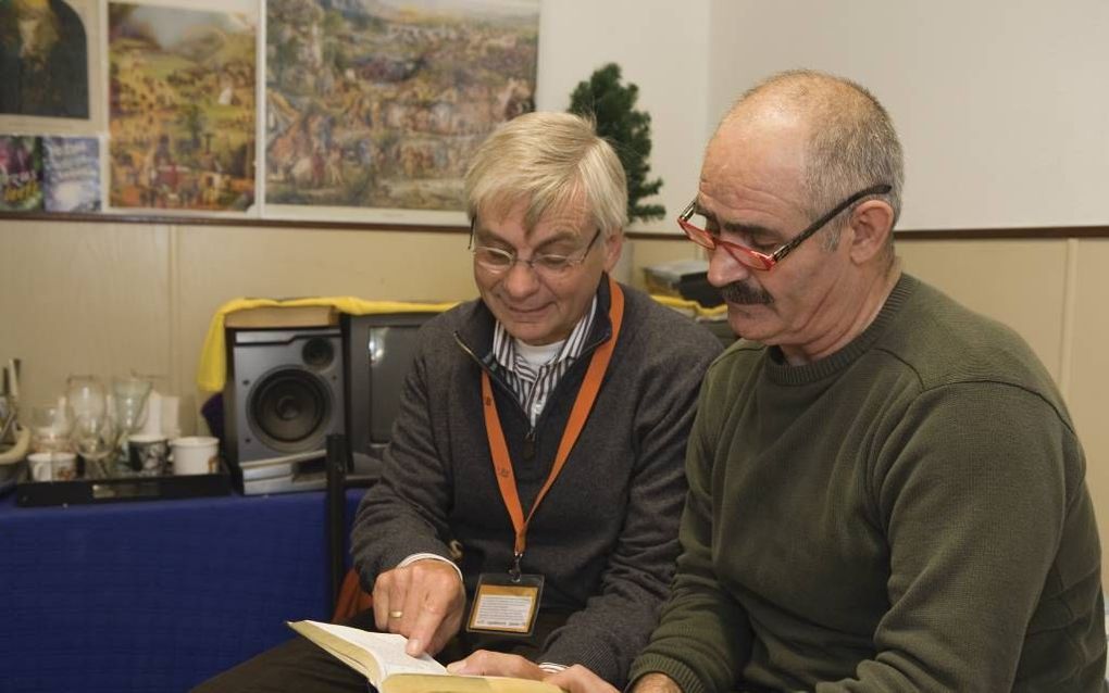 Visscher (l.) en Atar lezen samen uit de Bijbel. Foto Alida Stuut