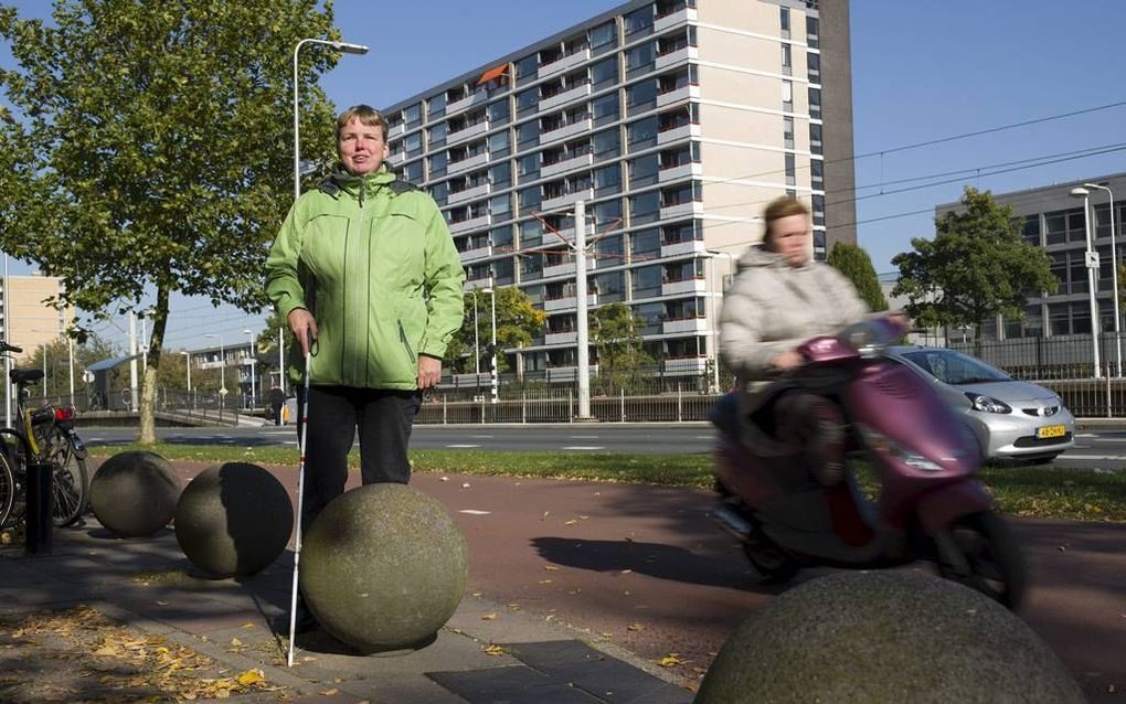 Nadat ze een voor haar gevaarlijk fietspad is gepasseerd, loopt de blinde Marga Zwanenburg vlak bij haar werk letterlijk aan tegen betonnen bollen die trottoir van fietspad moeten scheiden. Foto Erik Kottier