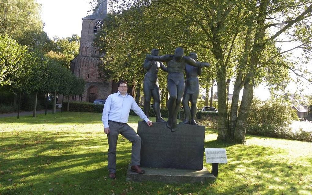 Dr. William den Boer bij het standbeeld van Veluanus in Garderen. Het kunstwerk van Gerard Overeem beeldt uit dat Veluanus wordt opgepakt vanwege zijn reformatorische prediking. Foto RD