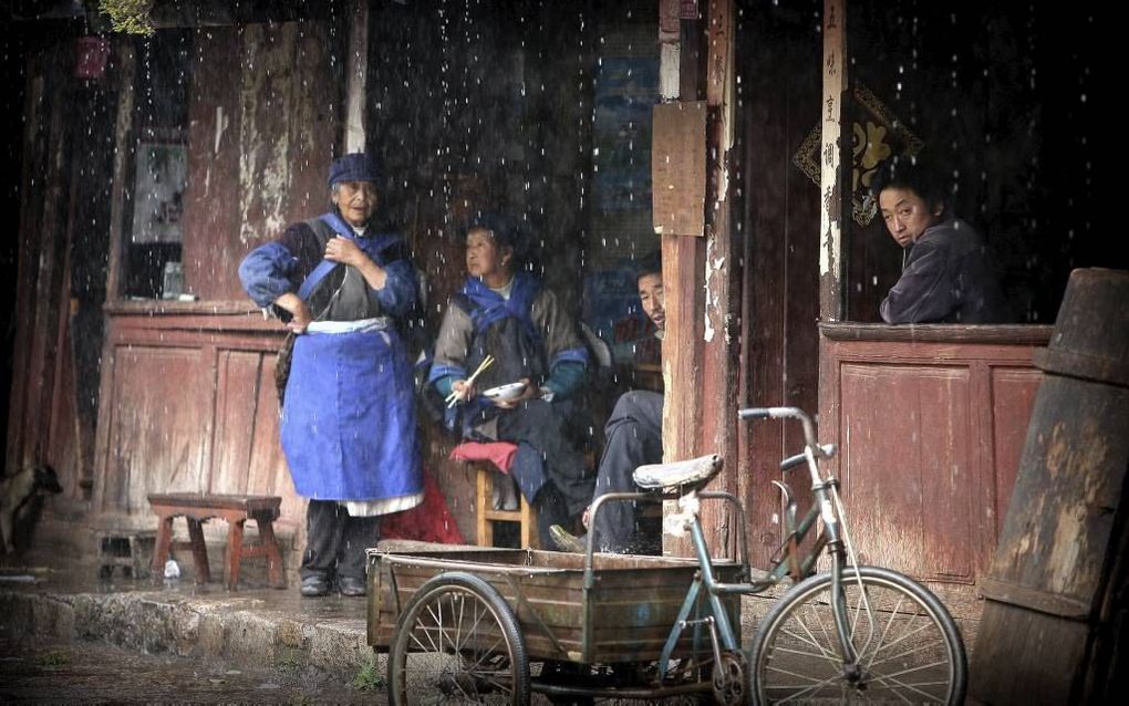 Boeren op het Chinese platteland wachten tot de regen is opgehouden. Foto RD, Henk Visscher