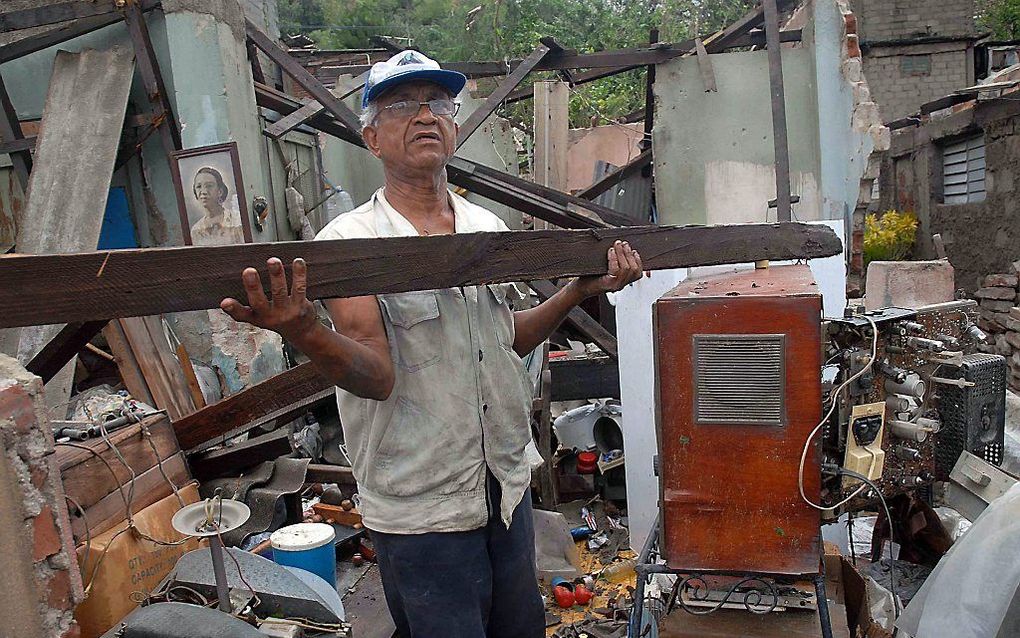 Een man uit Santiago op Cuba staat in zijn huis dat door orkaan Sandy is verwoest. Foto EPA