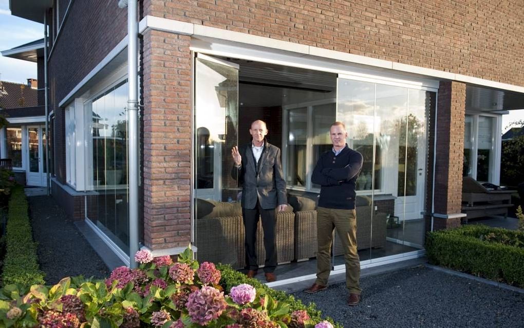 Hans Bahlman (r.) en zoon Thomas, die sinds kort in het bedrijf zit, laten zien hoe een terras met een wegklapbare wand windvrij is gemaakt.	Foto Cees van der Wal