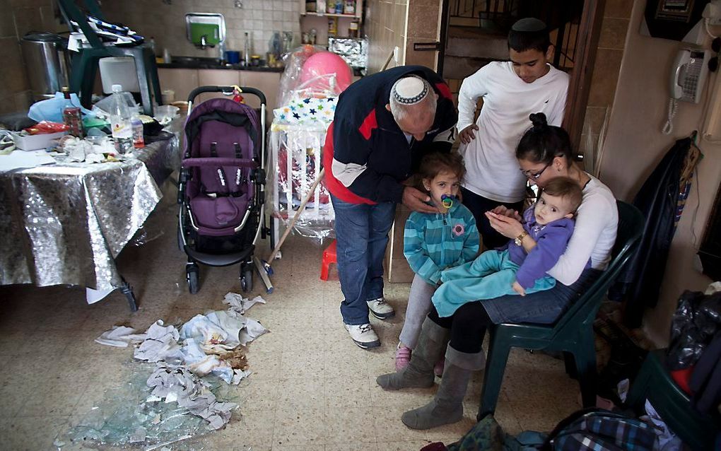 Gezinsleden buigen zich over een kind dat in shock is geraakt na een Palestijnse raketaanval op Netivot. Foto EPA