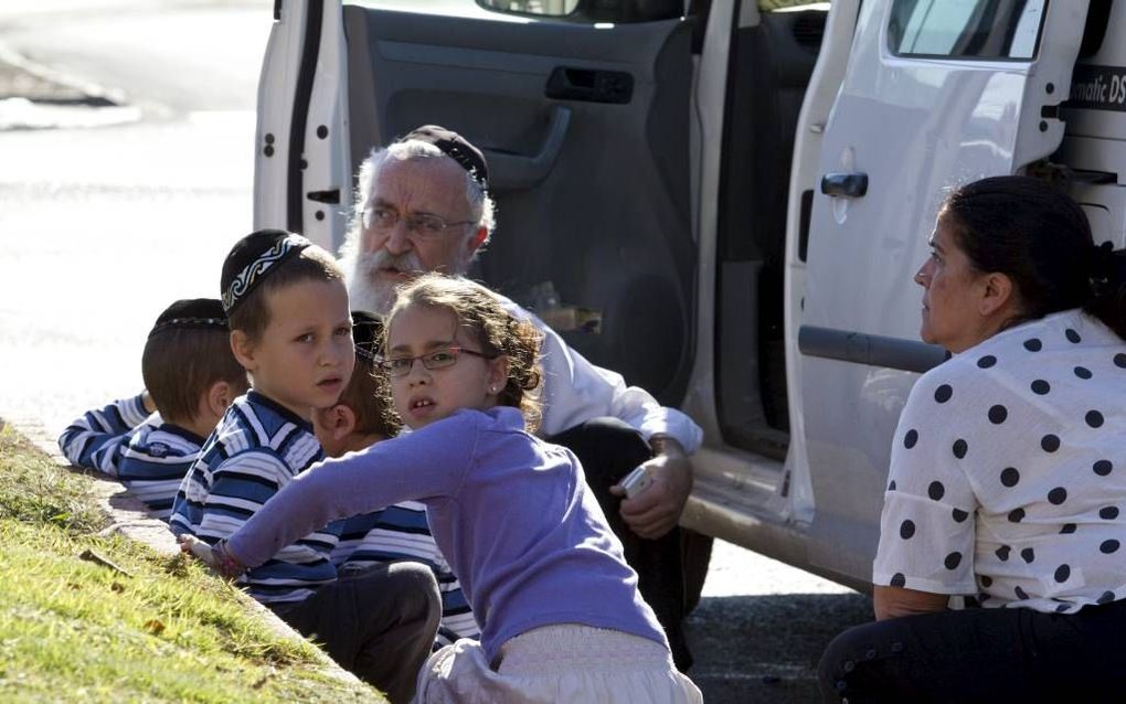 Israëli's zoeken dekking tijdens een raketbeschieting op Kiryat Malachai vanuit de Gazastrook, donderdag. Foto EPA