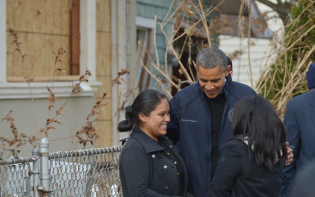 De Amerikaanse president Barack Obama praat met inwoners tijdens zijn bezoek aan delen van New York om de schade van superstorm Sandy te bekijken. Hij sprak onder meer met getroffen gezinnen en hulpverleners. Foto AFP