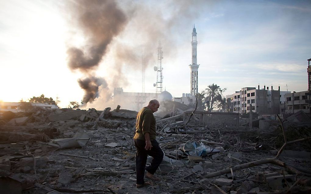 Een Palestijnse man loopt door het puin van vernietigde overheidsgebouwen in Gaza-Stad. Foto EPA