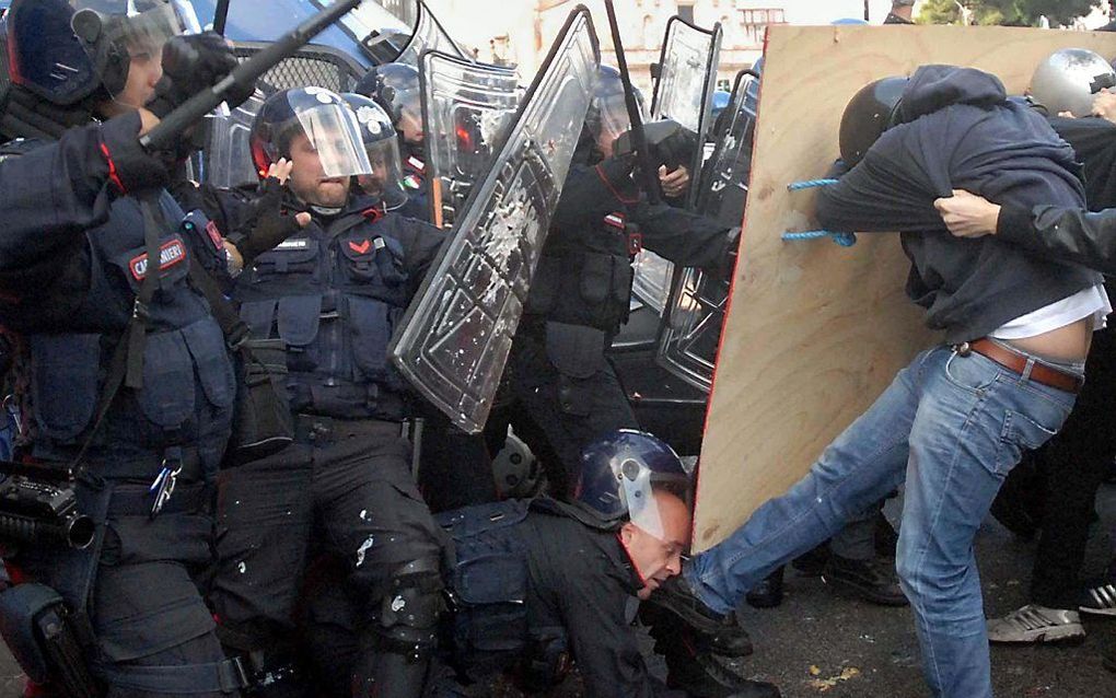 Een Italiaanse demonstrant schopt een politieagent in het gezicht. Foto EPA