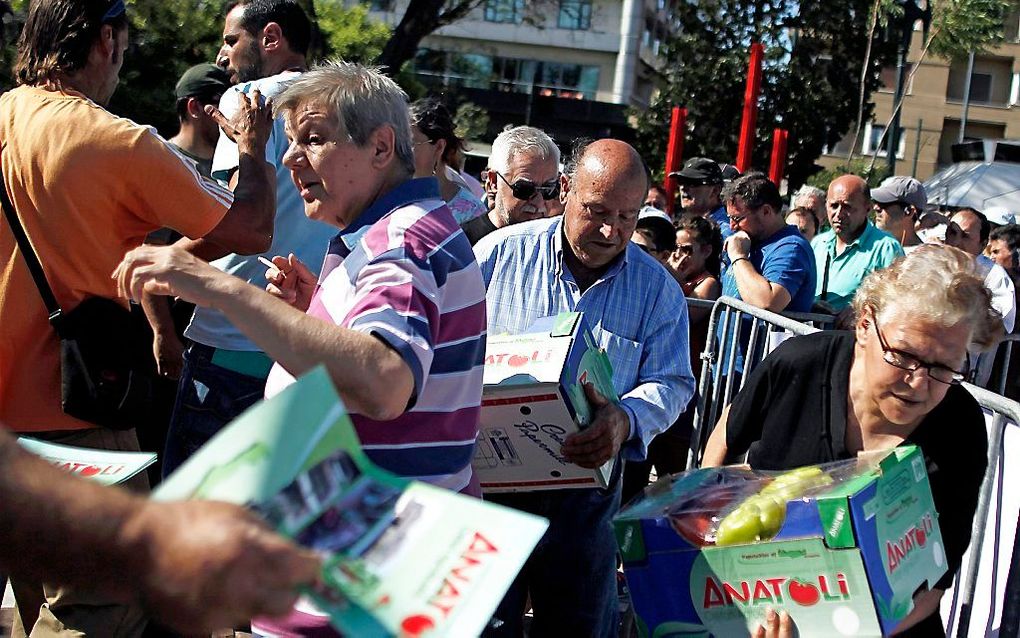 Werkloze inwoners van Athene staan in de rij voor gratis fruit, juni 2012. Foto EPA