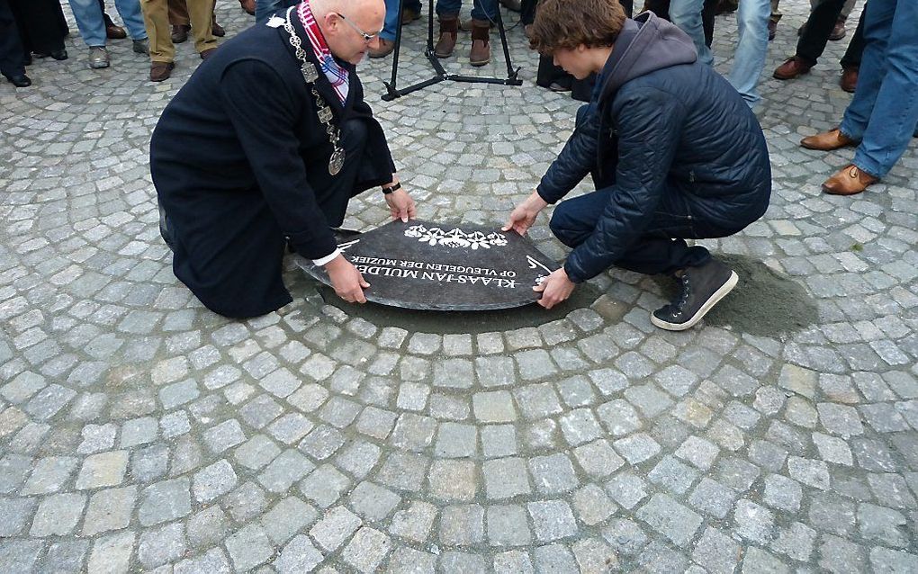 Kleinzoon Klaas Jan Mulder en burgemeester Koelewijn van Kampen plaatsen de steen voor musicus Klaas Jan Mulder op het Oude Raadhuisplein in Kampen. Foto Kamper Persclub, R. G. Busser