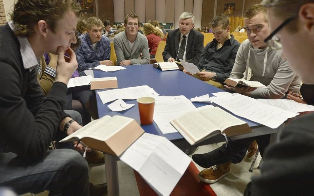 Jongeren van de Gereformeerden Gemeenten, in aanwezigheid van ds. C. Sonnevelt (foto), houden een Bijbelstudie tijdens de Check-in avond in Goes, afgelopen zaterdag. Foto W. Mieras