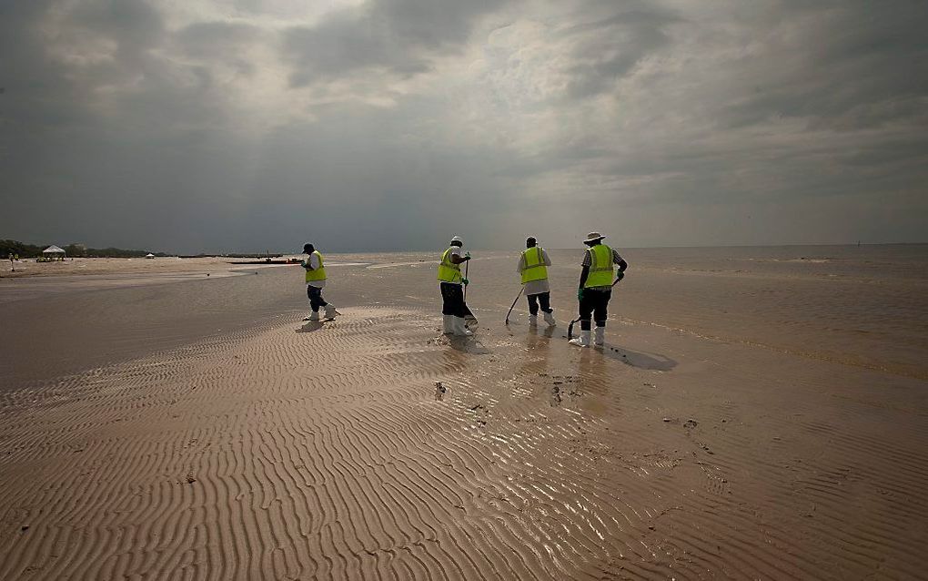 Olie op het strand wordt opgeruimd. Foto EPA