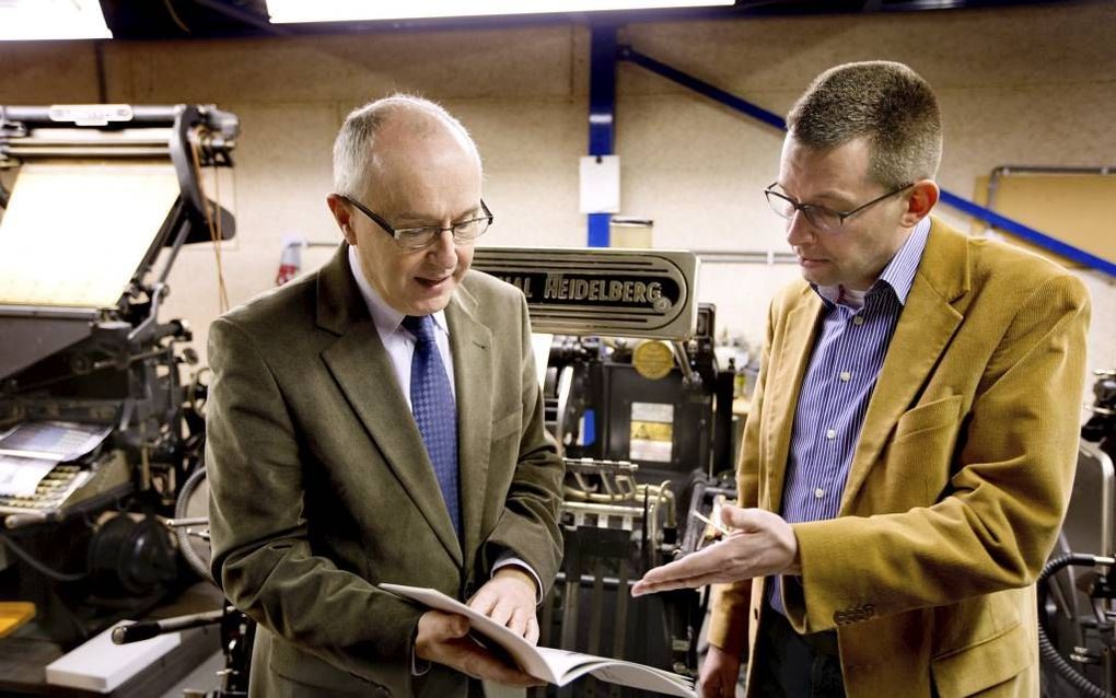 Tussen oude drukpersen in het museum van drukkerij RAD in Dordrecht heeft eindredacteur Peter Dillingh (r.) van het Historisch Tijdschrift GKN onlangs het eerste exemplaar van het jubileumnummer aangeboden aan ds. C. A. Streefkerk (r.) van de Ontmoetingsk