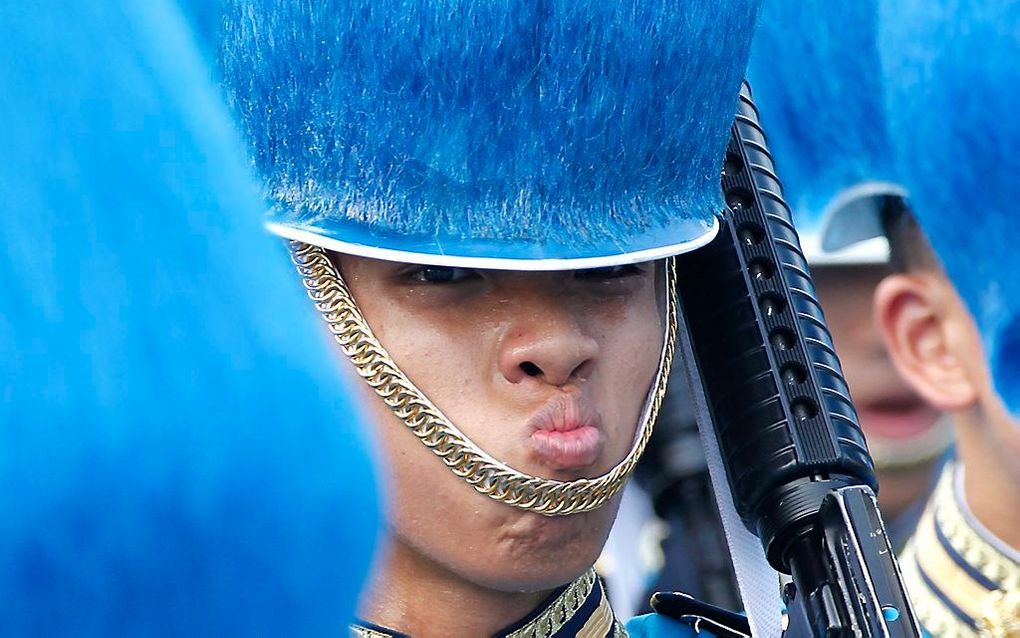 Een militair grimast tijdens een parade ter ere van koning Bhumibol Adulyadej. Foto EPA