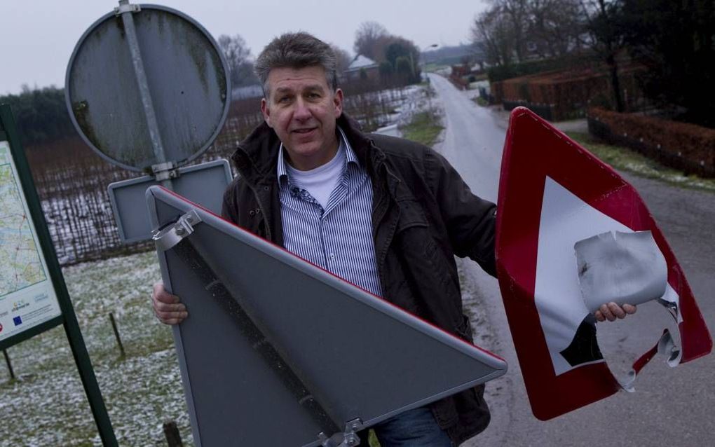 OPHEUSDEN – Willem Willemsen bedacht een beschermingssysteem voor verkeersborden. In zijn linkerhand een bord dat tijdens de jaarwisseling werd vernield, in zijn rechterhand een bord dat is uitgerust met het nieuwe systeem. Foto RD, Anton Dommerholt