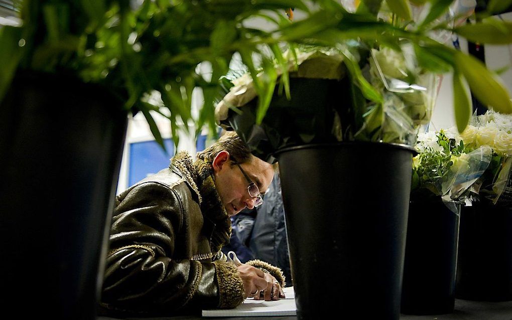 Een bezoeker tekent het condoleanceregister in de kantine van de SC Buitenboys.  Foto ANP