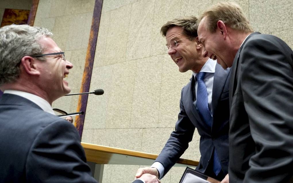 SGP-Kamerleden Dijkgraaf (l.) en Van der Staaij (r.) feliciteren premier Rutte in de Tweede Kamer met zijn 45e verjaardag. Foto ANP