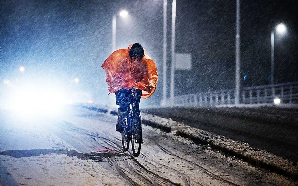 Fietser trotseert de sneeuw. Foto ANP