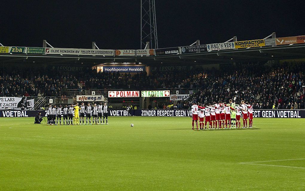 De spelers van Heracles en FC Utrecht nemen vrijdagavond voorafgaand aan de wedstrijd een minuut stilte in acht ter nagedachtenis aan de overleden grensrechter Richard Nieuwenhuizen. Foto ANP