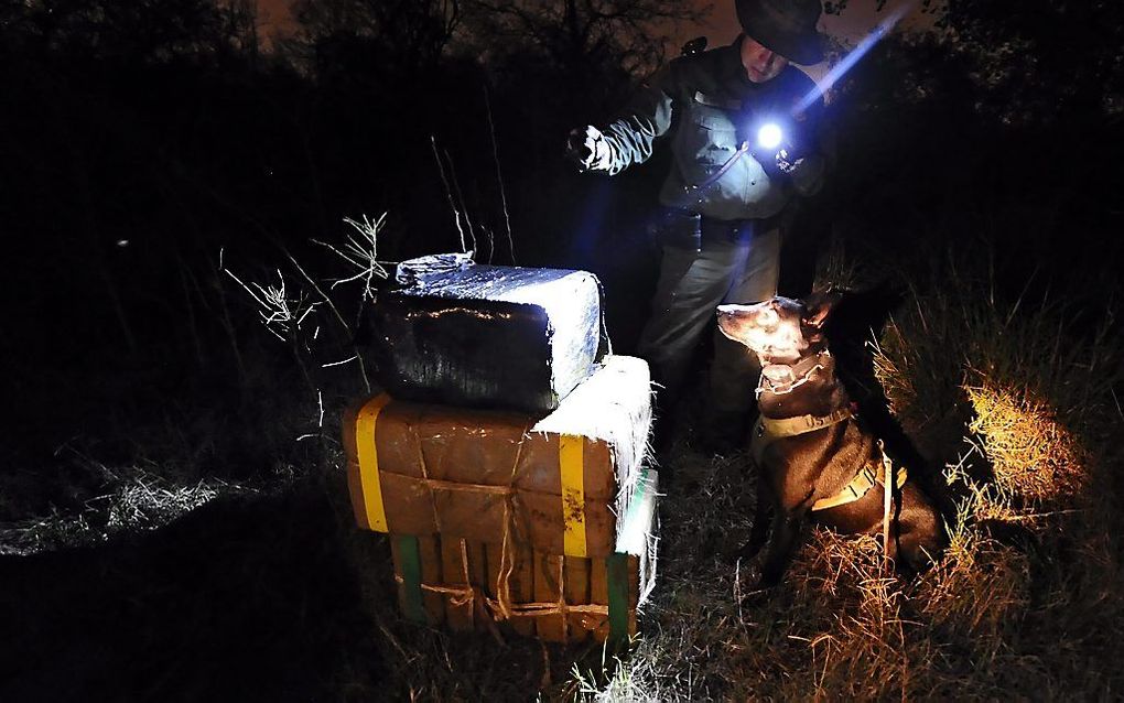 Een Amerikaanse grenswacht met een partij onderschepte drugs. Foto EPA