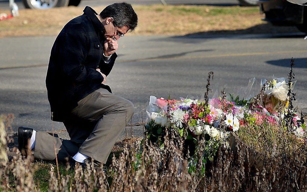 Een man laat zijn gedachten de vrije loop bij een gedenkplaats in de buurt van de Sandy Hook Elementary School. Foto EPA