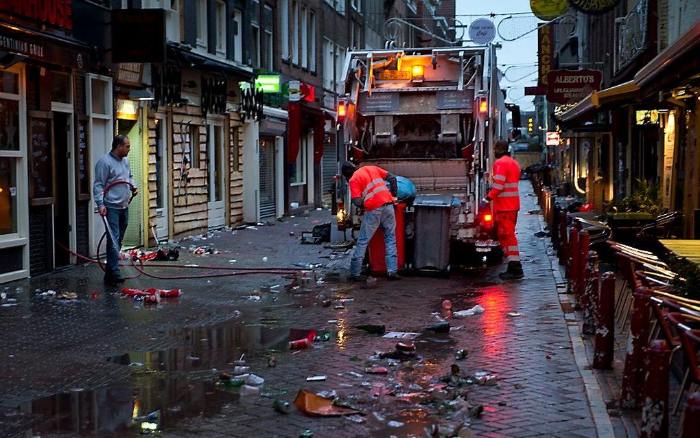 Na een nacht vol feestvreugde zijn de schoonmaakploegen goed voor de nette afhandeling. In deze fotoserie de Amsterdamse gemeentereiniging in actie om vuurwerkresten op te ruimen. Foto ANP