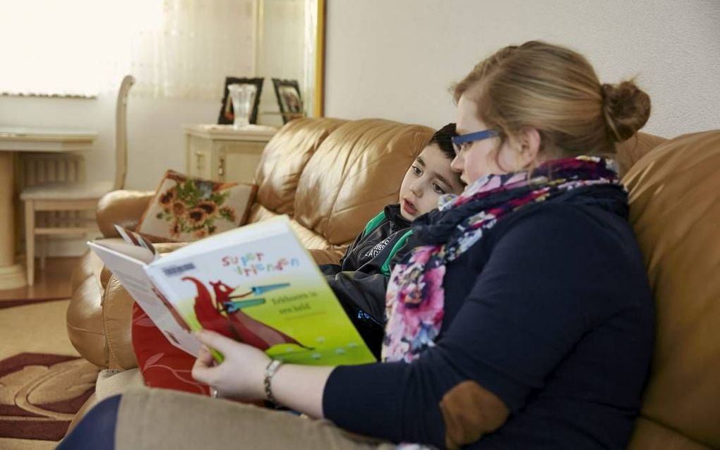 Studente Janneke den Breejen leest een boek niet zomaar van voor naar achter door, als ze bij Furkan is. Ze legt de nadruk op interactie. Juist daar leert de Turkse jongen van. Foto Jaco Klamer