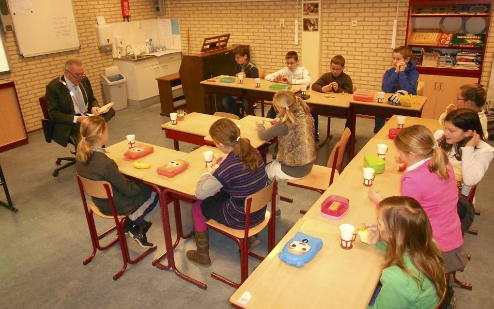 KRUININGEN – Burgemeester Huisman van Reimerswaal leest voor aan groep 7 van de Dr. A. Comrieschool in Kruiningen. Foto Linda Otte