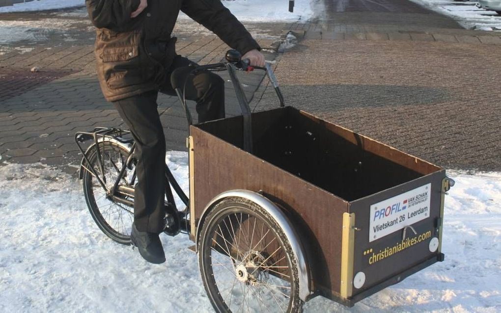 Adrie van Felius met de fiets waarin hij bijna dagelijks op pad gaat om oud papier op te halen bij particulieren en ondernemers. „De mensen rekenen op me.” Foto André Bijl