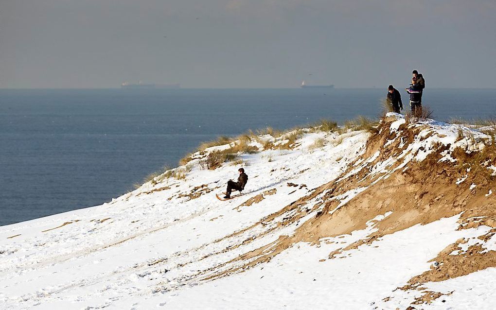 Kinderen vermaken zich met de slee in de duinen bij Den Haag.  Foto ANP