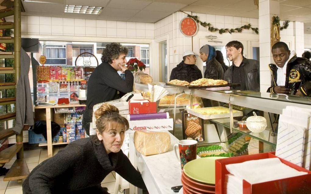 Fotograaf Rufus de Vries toont ontmoetingen in de Amsterdamse wijk Slotervaart. Foto: student geneeskunde Rein komt bij Abi in de snackbar patat halen. Foto Rufus de Vries