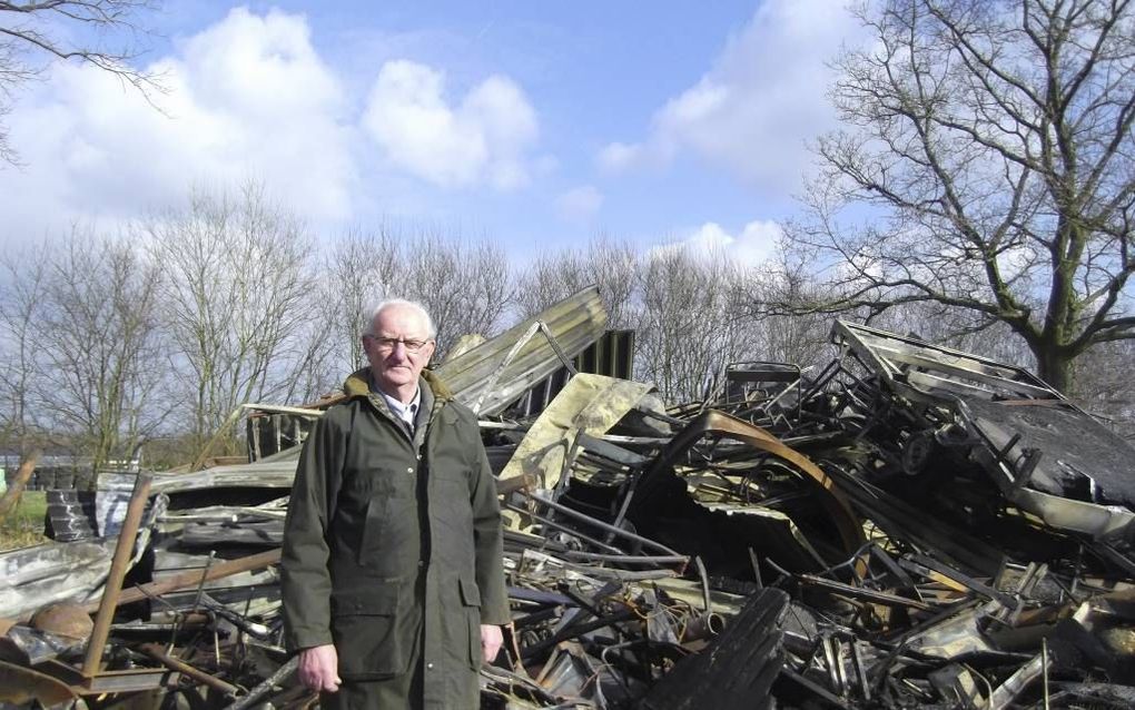 Henk Schoonhoven (72) voor de restanten van zijn loods die maandag afbrandde. Van de hulpgoederen voor Oost-Europa die er in lagen, is niets meer over. Foto RD