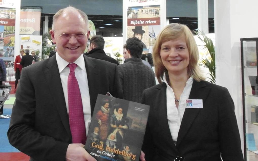 Prof. dr. H. J. Selderhuis en Karla Apperlo met het boek ”God, Heidelberg en Oranje. 450 jaar Heidelbergse Catechismus”, dat dinsdag in Utrecht werd gepresenteerd. Foto RD