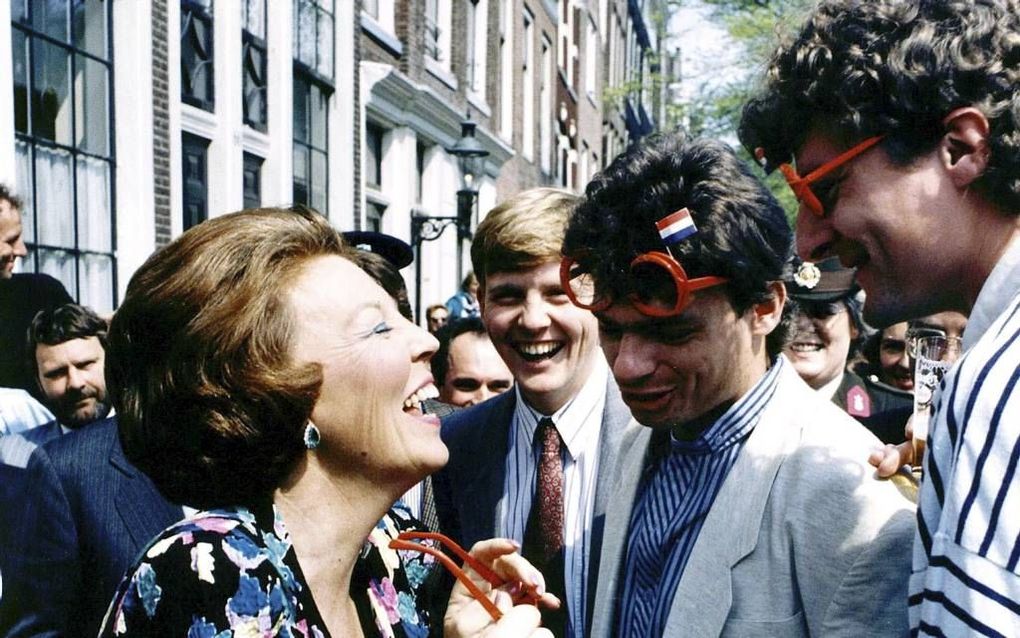 Aansluitend aan de koninginnedagvieringen in Overijssel brengt de koningin in 1988 een verrassingsbezoek aan de vrijmarkt in Amsterdam. Een omstander geeft haar spontaan een zoen.  Foto ANP