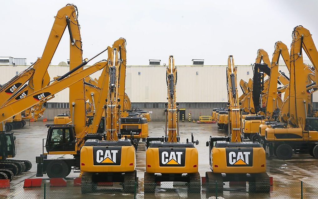 Het zijn stoere voertuigen, die graafmachines van Caterpillar. Achter de fabriekspoort is de romantiek wat minder groot donderdag. De fabrikant is van plan 1400 banen te schrappen.  Foto EPA