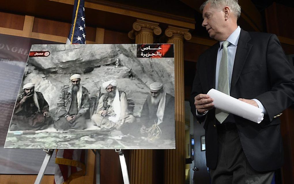 Senator Lindsey Graham kijkt naar een foto met daarop onder andere Sulaiman Abu Ghaith (l.), zittend naast Osama bin Laden (2e van links). Foto EPA