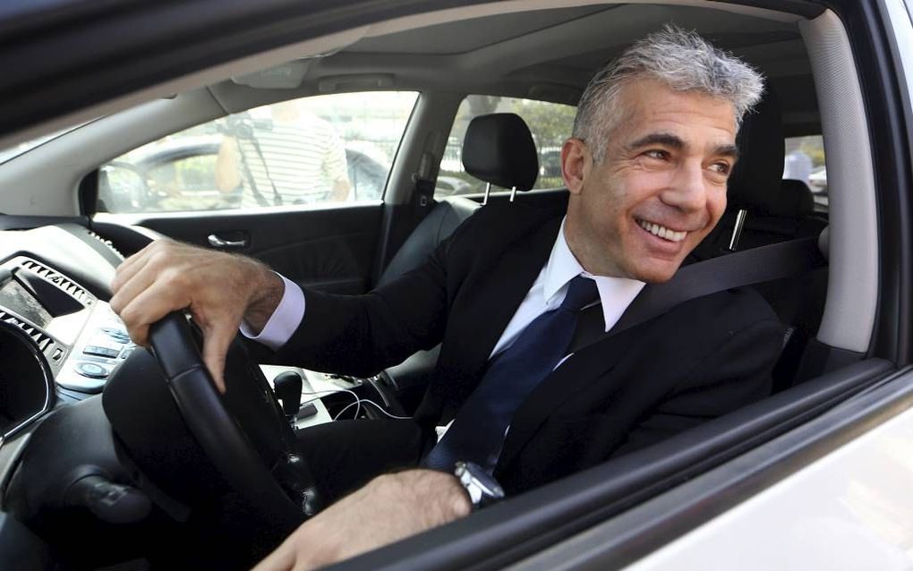 De leider van de middenpartij, Yair Lapid, maandag bij het kantoor van de premier in Jeruzalem. Hij wordt waarschijnlijk namens zijn partij Yesh Atid minister van Financiën.	Foto EPA