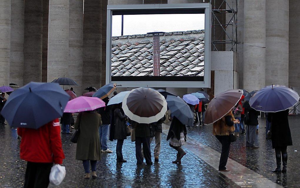 Het conclaaf heeft vanavond nog geen paus gekozen. Er kwam zwarte rook uit de schoorsteen. Foto: videoschermen op het Sint-Pietersplein projecteren de schoorsteen op de Sixtijnse Kapel. Foto EPA