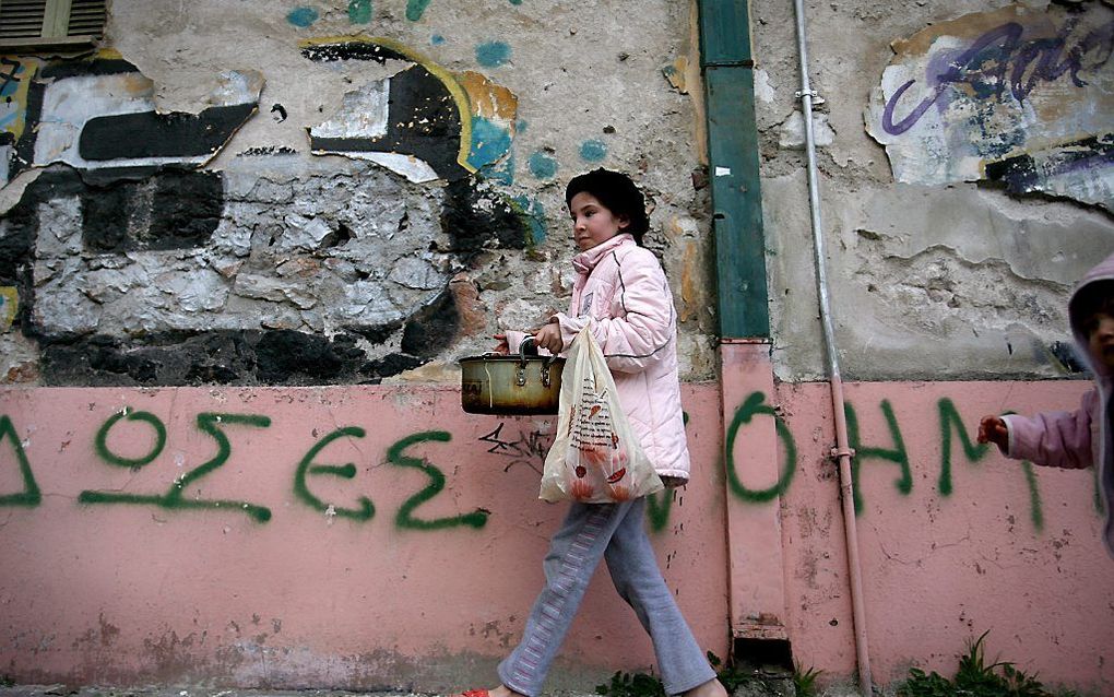 Een meisje in Athene, onderweg van de gaarkeuken naar huis. Foto EPA