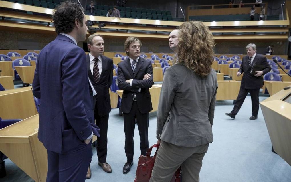 Woordvoerders in het debat over het schrappen van de strafbaarheid van smalende godslastering praten na afloop nog even na. V.l.n.r. Van Dam (PvdA), Van der Staaij (SGP), Taverne (VVD), Segers (CU) en Bergkamp (D66). Op de achtergrond minister Opstelten v