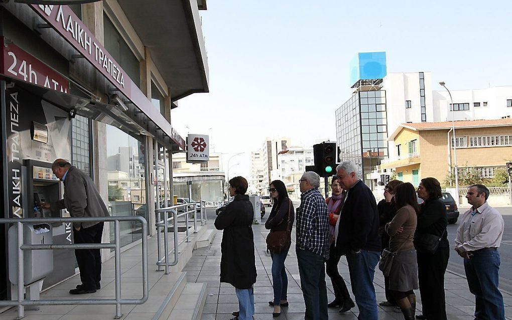 Inwoners van Cyprus donderdag in de rij voor een pinautomaat. Foto EPA